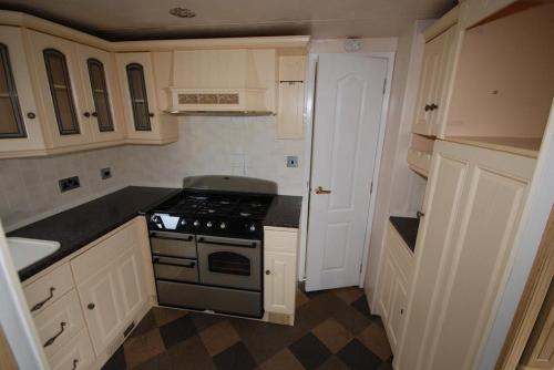 a small kitchen with a stove and white cabinets at Noclegi Dorotowo in Dorotowo