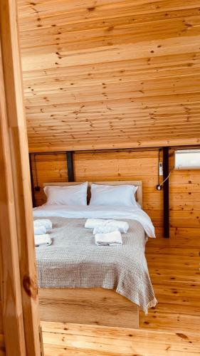 a bedroom with a bed in a wooden room at Akhalsheni House in Batumi