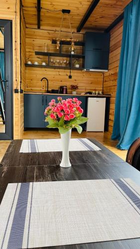 a vase filled with pink flowers sitting on a table at Akhalsheni House in Batumi