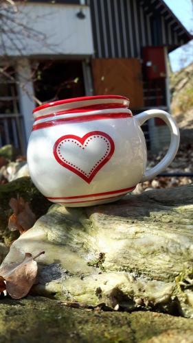 a red and white cup sitting on top of a tree stump at Chata Libošovice 109 in Libošovice