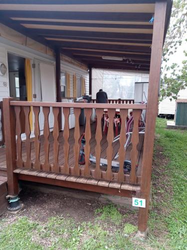 un banc en bois avec des attaches accrochées à une clôture dans l'établissement Camping l'escale, à Agde
