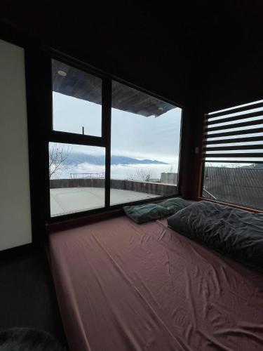 a bedroom with a bed and a large window at Cloud Garden in Bắc Yên