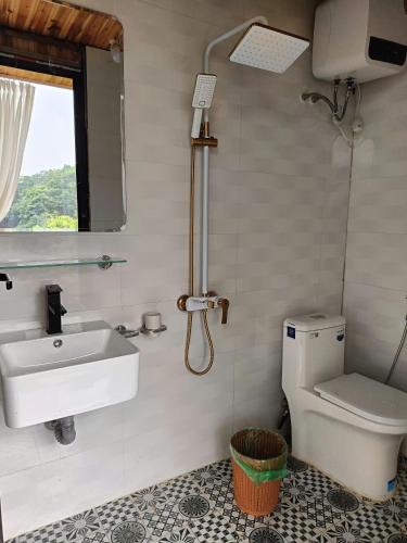 a bathroom with a sink and a toilet and a window at Cloud Garden in Bắc Yên