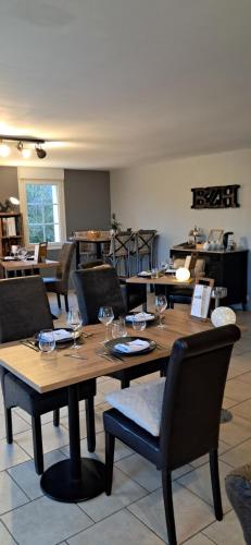 - une table et des chaises en bois avec des verres à vin dans l'établissement La Maison des Poulains, à Sauzon