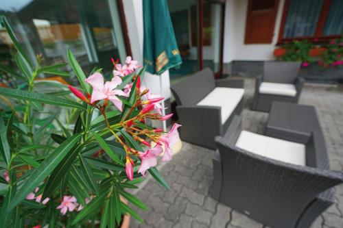 a group of tables and chairs with pink flowers at Landhotel Gasthof Zwota in Klingenthal