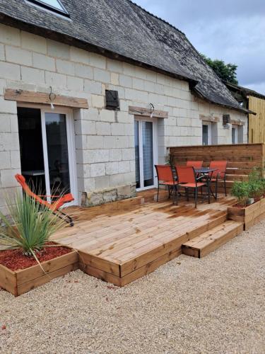 une terrasse en bois devant une maison dans l'établissement Les deux tilleuls, à Les Rosiers
