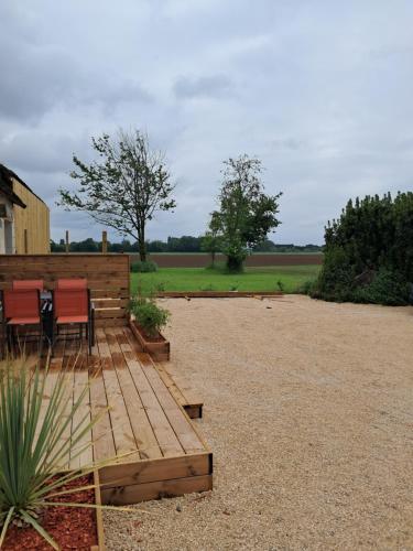 un patio avec une table et des chaises dans une cour dans l'établissement Les deux tilleuls, à Les Rosiers