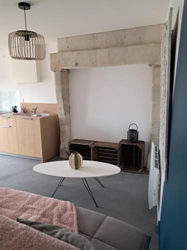 - un salon avec une table et un lavabo dans l'établissement Les deux tilleuls, à Les Rosiers