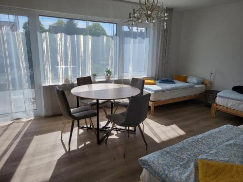 ein Wohnzimmer mit einem Tisch, Stühlen und einem Bett in der Unterkunft Emily Apartments, moderne ruhige Wohnung, nur 4 km von der A2 in Leopoldshöhe