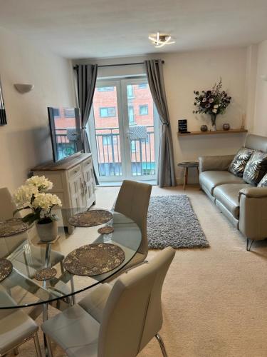 a living room with a glass table and a couch at City Centre apartment. in Wrexham