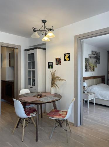 a dining room with a table and chairs and a bed at DimaX Apartments in Budva