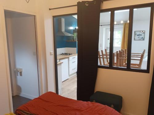 a room with a bed and a kitchen with a mirror at Le Petit Herbauges in Bouaye