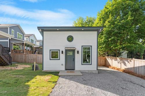 a small white shed with a door in a yard at The Raleigh Nook - near Lenovo Center & Fairground in Raleigh