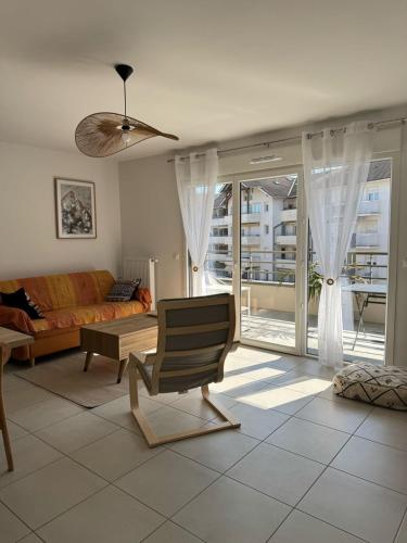 un salon avec un canapé et une chaise dans l'établissement La Datcha - New T3 with balcony & parking near train station, à Aix-les-Bains