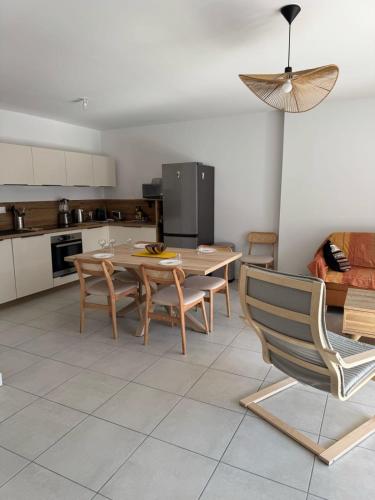 une cuisine et une salle à manger avec une table et des chaises dans l'établissement La Datcha - New T3 with balcony & parking near train station, à Aix-les-Bains