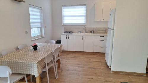 a kitchen with a table and a white refrigerator at רגעים בגולן in Keshet