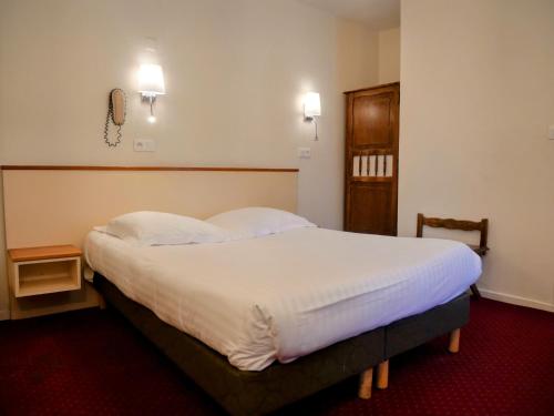 a bedroom with a large bed with white sheets at Hotel Iena in Angers