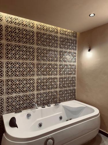 a white bath tub in a bathroom with a tile wall at Big Apartment in Central Medina 3BR ,view and Jacuzzi Tetouan in Tetouan