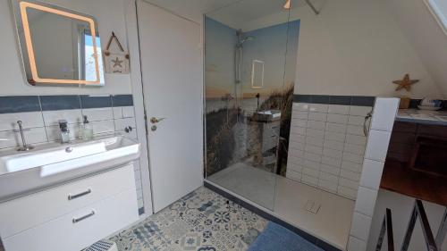 a bathroom with a shower and a sink and a mirror at Charmantes Ferienhaus in Nordfriesland in Humptrup