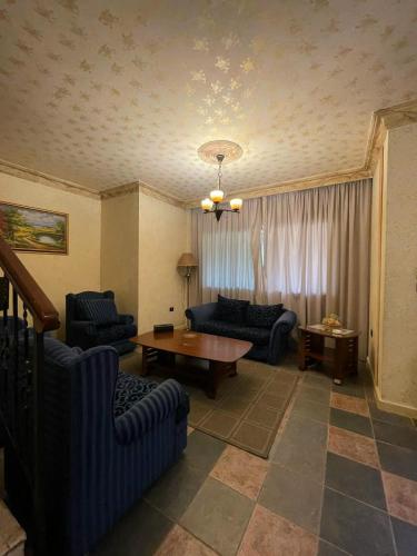 a living room with two couches and a table at Pineland Hotel and Health Resort in Ḩammānā