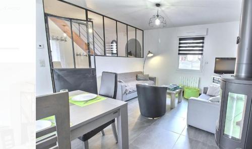 un salon avec une table, des chaises et un canapé dans l'établissement L'horizon, à Plurien