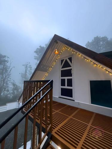 a small white house with lights on a deck at Minnaminni Estates in Munnar