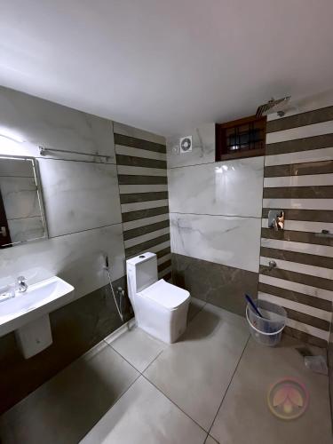 a bathroom with a white toilet and a sink at Minnaminni Estates in Munnar