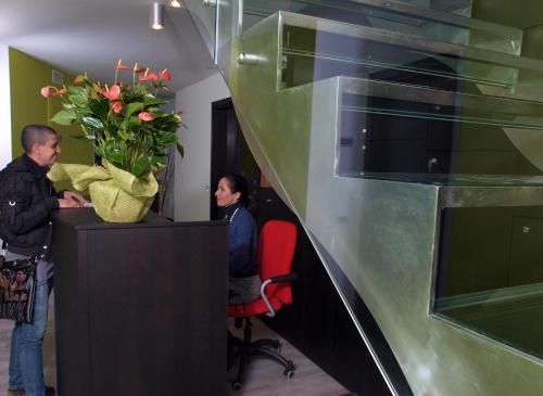 a man and a woman in an office with a desk with flowers at Casepicarmo Guest House in Augusta