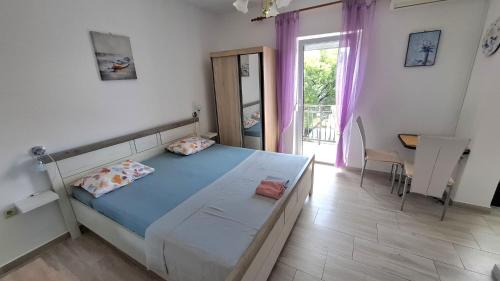 a bedroom with a bed and a table and a window at Guesthouse Martina in Senj