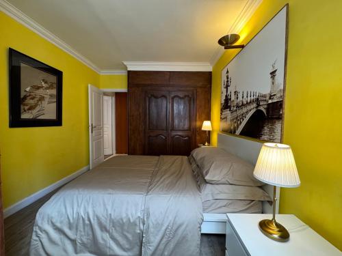 a bedroom with yellow walls and a bed and a lamp at Red Flat Paris in Paris