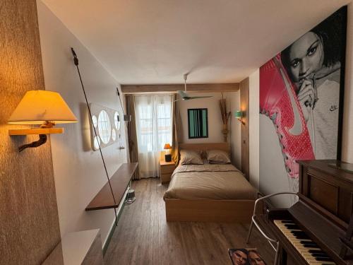 a small bedroom with a bed and a piano at Red Flat Paris in Paris