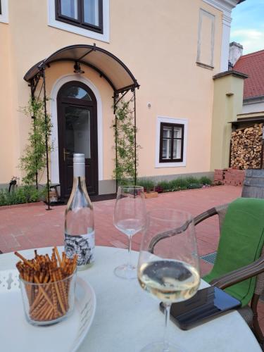 a table with two glasses and a bottle of wine at Bem Villa Apartman, Kőszeg in Kőszeg