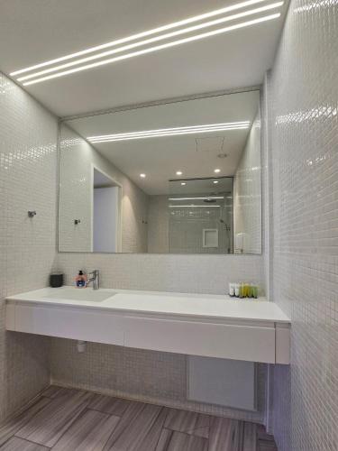 a bathroom with a sink and a large mirror at City Centre Studio Apartments Nicosia in Nicosia