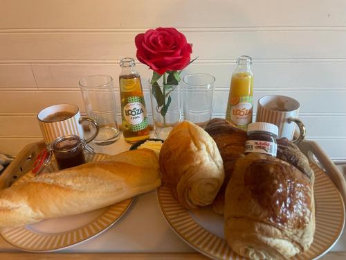ein Tisch mit zwei Tellern Brot und einer Rose in der Unterkunft Le petit chalet in Brêmes