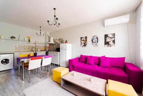 a living room with a purple couch and a table at Апартамент Веирас 2 in Velingrad