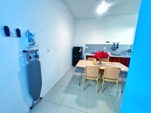 a dining room with a table and chairs with flowers on it at Santorini Vibes Penang - Tasek Gelugor in Kampong Selamat
