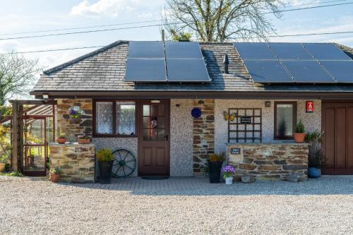 a house with solar panels on the roof at Wheel Cottage, Landrake in Saltash