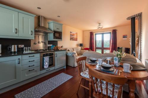 a kitchen and living room with a table and a couch at Wheel Cottage, Landrake in Saltash
