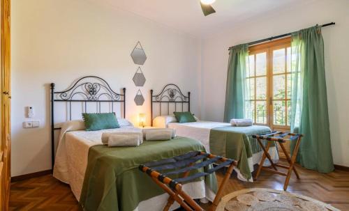 2 letti in una camera con verde e bianco di Villa El Torreón a Casarabonela