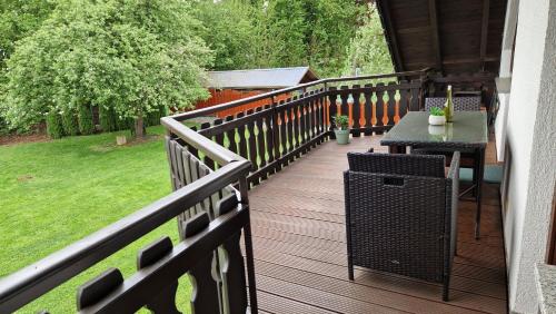 a deck with a table and a table on a porch at Ferienwohnung Wolkennah in Sohren