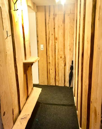 a hallway with wooden walls and a cat standing in a room at Im kleinen Paradies in Schopfheim