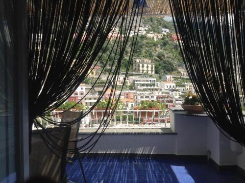 a room with a view of a city from a window at Azul Apartment in Positano
