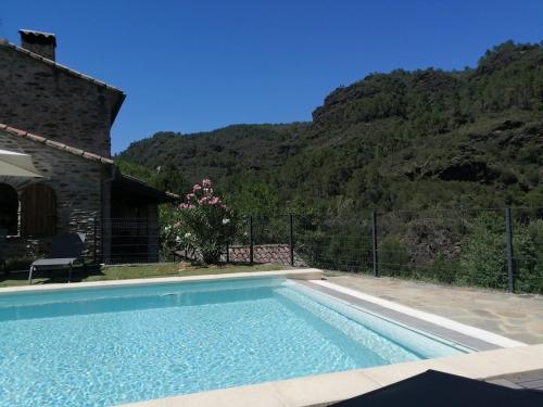 une piscine devant une maison avec une montagne dans l'établissement Maison avec piscine dans les Cévennes, à Saint-Paul-la-Coste