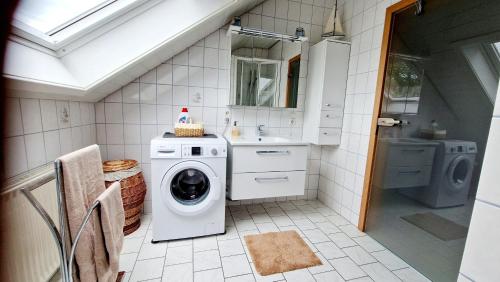 a bathroom with a washing machine and a sink at Ferienwohnung Wolkennah in Sohren