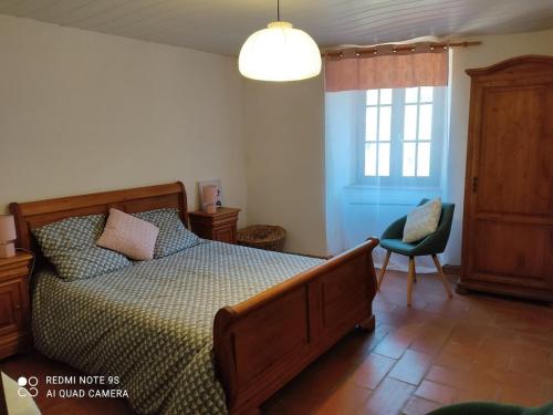 une chambre avec un lit, une chaise et une fenêtre dans l'établissement Maison avec piscine dans les Cévennes, à Saint-Paul-la-Coste