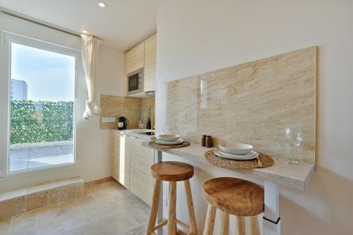 une cuisine avec un comptoir, des tabourets et une fenêtre dans l'établissement Welcome to Corsica Love, à Alfortville