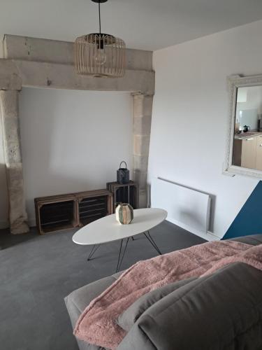 un salon blanc avec une table et un canapé dans l'établissement les deux tilleuls, à Les Rosiers