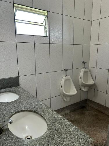 a bathroom with two sinks and two urinals on a wall at CHÁCARA recanto das nuvens 2 in Arujá