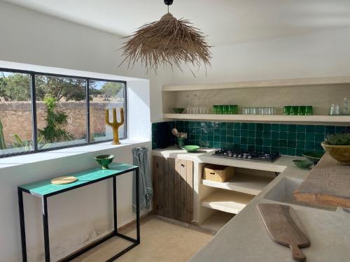 a kitchen with a counter and a sink and a window at Palais Bleu Nomade Essaouira in Aït Imouni