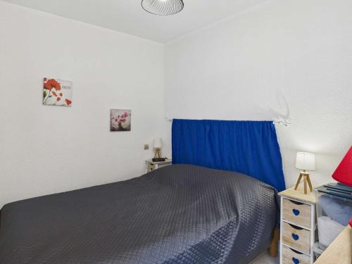 une chambre avec un lit bleu et un rideau bleu dans l'établissement Appartement cosy 2 pièces, 4 pers., à 2 pas de la plage, parking privé, terrasse avec salon de jardin - FR-1-326-815, à Marseillan